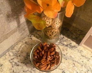 Whole pecans in small bowl on countertop